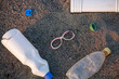 A bottle of water is on the ground next to a pair of glasses