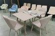 Beige wooden table complete with beige wooden chairs with soft fabric upholstery. Green saucer on the table