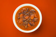 Beef stew on red background with copy space, top view