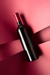 Bottle of red wine on a red background.