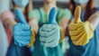 Smiling people giving thumbs up in multi-colored latex gloves. Close-up studio shot with vibrant colors