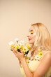 Portrait of a pretty girl with a bouquet of chrysanthemums. White and yellow flowers and petals on the face. Beauty concept