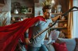 A young man dons a superhero costume and cape while using a vacuum cleaner in a home setting