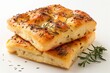 Golden focaccia bread pieces sprinkled with herbs on a white background, accompanied by rosemary