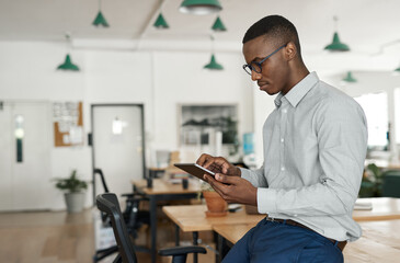 Young African businessman using a tablet at his office desk