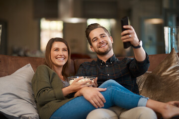 Canvas Print - Couple, popcorn and remote control for watching tv on the couch, relax at home for bonding and streaming. Movie, show or video, people and time together with corn snack, change channel and smile