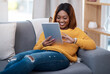 © peopleimages.com - Tablet, search and happy black woman on sofa with social media, reading or website scroll at home. Digital, research or student with streaming app for sign up, online course or elearning registration