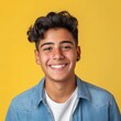 Radiant Hispanic teenager with a cheerful smile, sporting a yellow t-shirt, set against a matching vibrant yellow background — a portrait of youthful optimism and style.