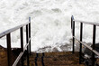 Ocean Waves Coming Up To Bottom Of Steps Down To Beach