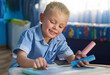 © peopleimages.com - Home, boy and writing on chalkboard, education and fun activity with creativity or artwork. Child development, house and kid with idea or smile with student or hobby for learning, drawing or carefree