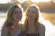© olegganko - Two Young Women Laughing and Looking at Each Other