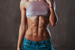 Young slim sports woman showing abdominal muscles