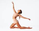 Fototapeta Sypialnia - Young woman gymnast stretching on white background