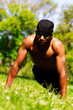 Young African American Man Doing Pushups In Park Strong Sunlight