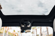 Panoramic sunroof at the car and blue sky and palms. Clean sunroof and view of the sky from the inside or car interior