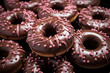 chocolate donuts with pink icing and sprinkles stacked on top of each other