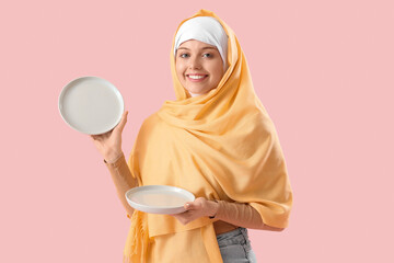 Canvas Print - Beautiful Arabian woman with empty plates on pink background