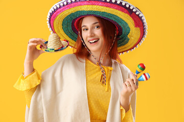 Canvas Print - Young woman with sombrero hats and maracas on yellow background. Mexico's Day of the Dead (El Dia de Muertos) celebration