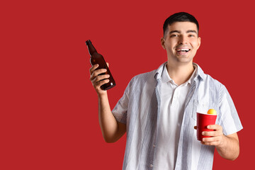 Poster - Young man with beer and ball on red background