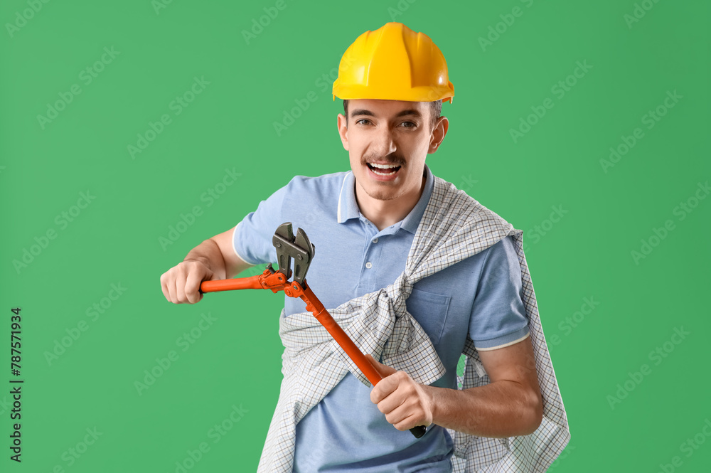 Male worker with wrench on green background