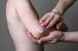 allergy on the elbows in a child, rash and redness, atopic dermatitis, women's hands apply ointment and cream to eczema areas