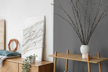 Vase With Willow Branches On Shelf In Modern Living Room