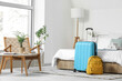 © Pixel-Shot - Interior of light hotel room with suitcase and backpack near bed