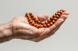 Islamic pray gesture with open hand and prayer beads over white background