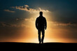 The image depicts a lone man's silhouette against the sunset, evoking contemplation and solitude