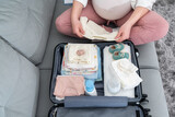 Fototapeta Miasto - Top view of a pregnant woman packing a set of necessary things in the maternity hospital
