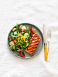 Delicious diet lunch, dinner - grilled salmon and fresh vegetable salad on a light background, top view