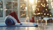   A yoga mat adorned with a Santa hat rests near a tree, while another mat is positioned in front for holiday practice