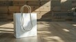 A white shopping bag with a nylon rope handle is lying on the floor
