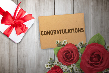 Wall Mural - A gift box with a flower bouquet and greeting card with Congratulations text