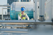 © ultramansk - Construction engineer on a rooftop checking HVAC systems, with urban skyline in the distance