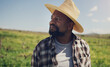 © peopleimages.com - Black man, farmer and thinking with hat on grass field for agriculture, sustainability or natural growth in countryside. African male person in wonder or thought for eco friendly environment on farm