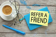 Refer a friend symbol. top view of a cup of coffee and glasses. blue notepad and text on paper