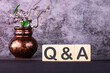 Word Q and A made with wood building blocks on a gray background.