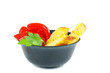 Red tomatoes and polenta pieces in black ceramic bowl. Isolated on white background