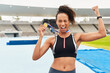 Black woman, athlete and victory with medal stadium as champion for competition or game in Brazil. Portrait, winner and wink with prize or award for success, achievement and happy for sport career