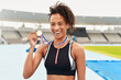 © peopleimages.com - Portrait, winner and athlete with gold medal, sports and stadium for competition. Victory, racetrack or celebration for sprinter and award on field, athletics or cardio event for female runner person