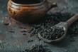 dry black tea leaves in a spoon freshly brewed in a cup