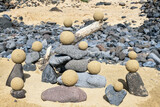 Fototapeta Las - Pretty pile of wooden pebbles and balls of sand facing the sea