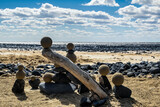 Fototapeta Las - Pretty pile of wooden pebbles and balls of sand facing the sea