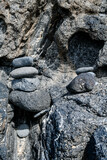 Fototapeta Las - Pretty pile of pebbles between the rocks