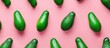 Green avocados arranged in a minimal flat lay style on a pink background, a pop art design representing a creative summer food concept. Top view banner image.
