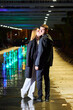 A beautiful young couple. A girl in white clothes and a man in black clothes at night in the park.
