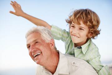 Wall Mural - Happy, blue sky and child playing with grandfather for bonding, relationship and relax together outdoors. Family, nature and grandpa with young boy on summer holiday, vacation and weekend at park