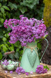 Oster-Arrangement mit Flieder-Blumenstrauß im vintage Krug und Ostereiern im orb