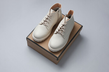 Sticker - New white leather boots with box on gray background